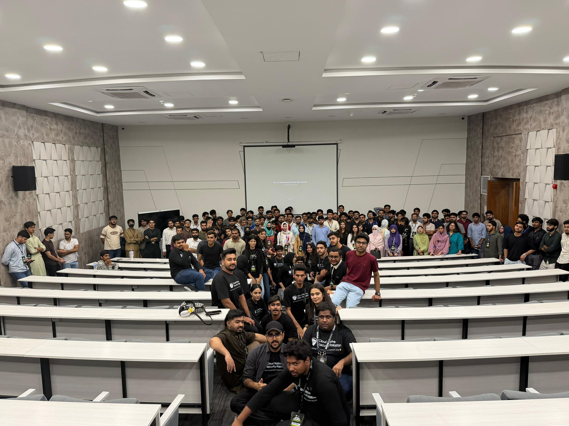 Wide view of the community group gathered inside the tiered lecture hall
