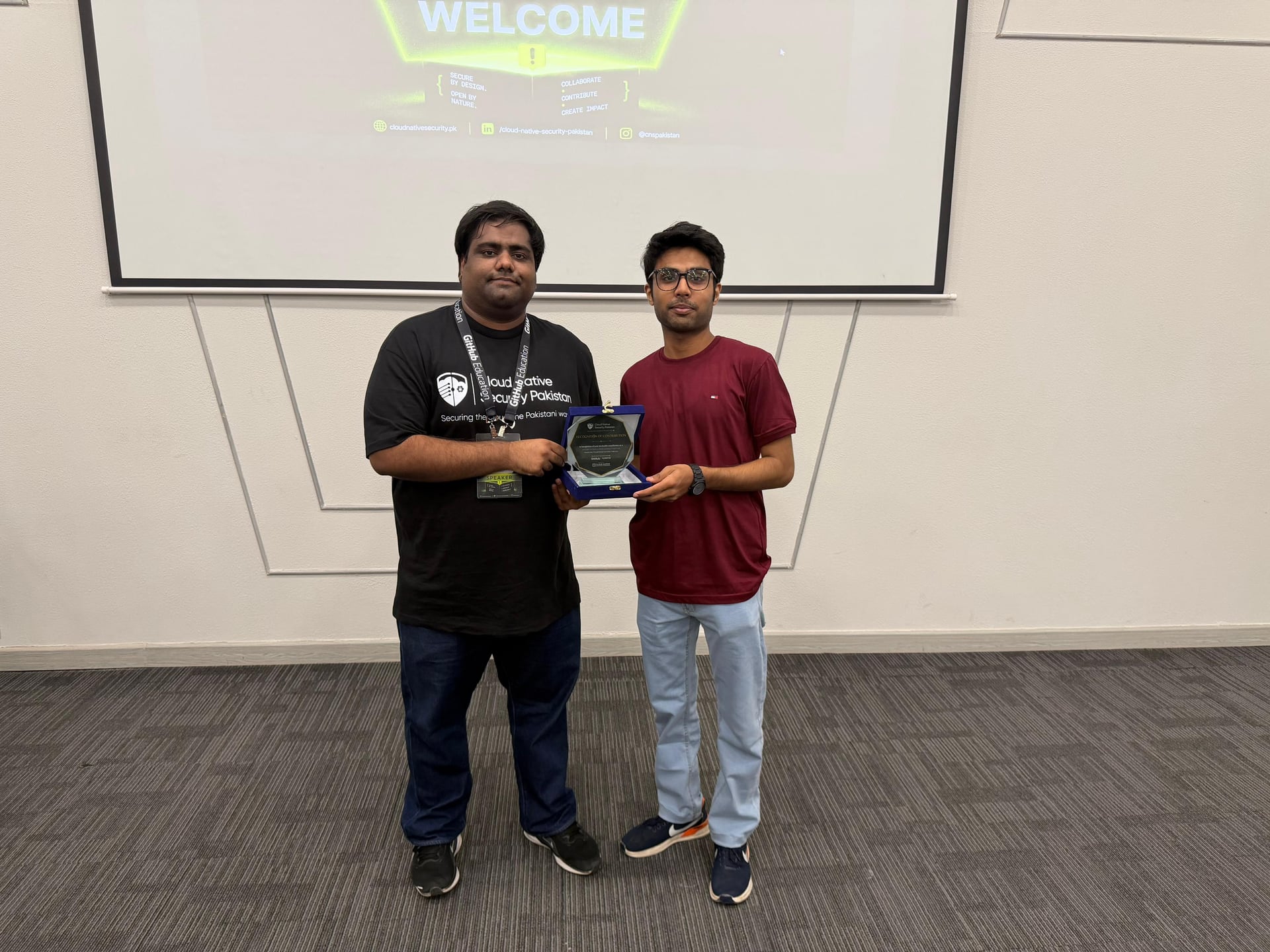 Mahad and a Cloud Native Security Pakistan organizer hold a speaker recognition plaque